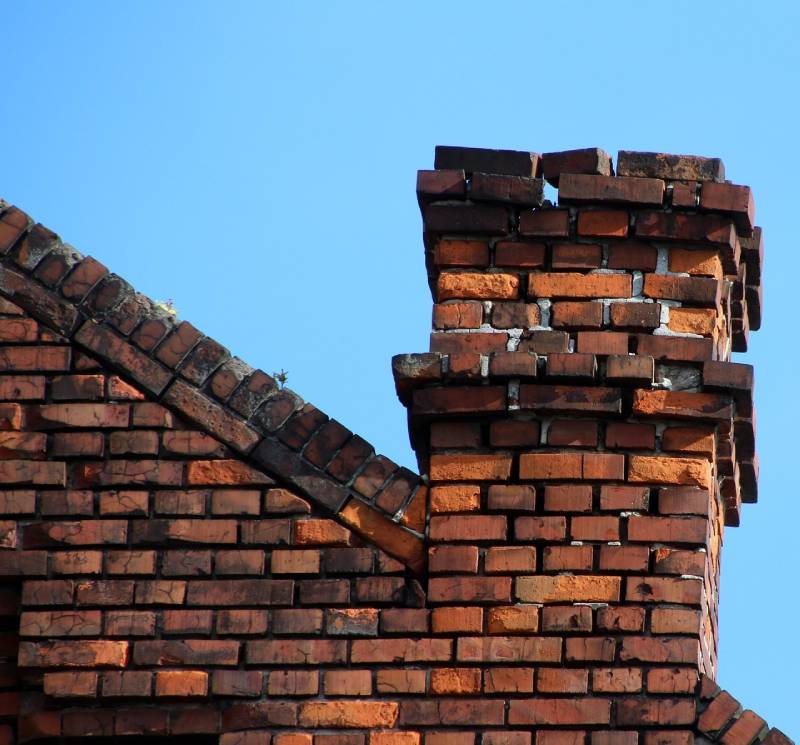 Damaged chimney on an Dallas home showing cracks and missing mortar